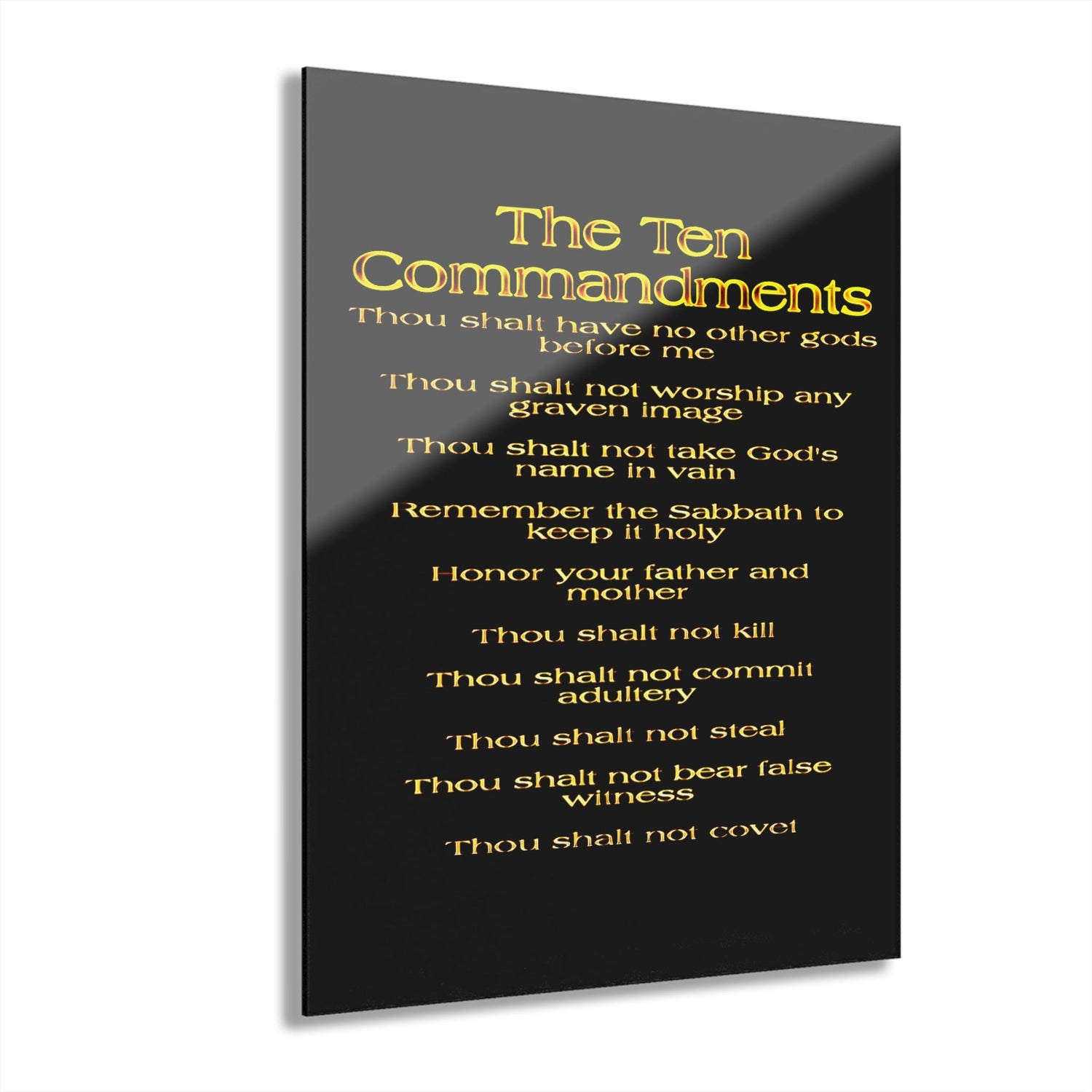 A black acrylic print with gold text listing the Ten Commandments, starting with "Thou shalt have no other gods before me" and ending with "Thou shalt not covet."