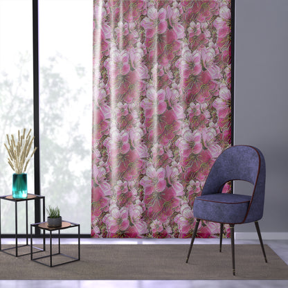 Modern room with a purple velvet chair and pink cherry blossom curtains hanging in front of a large window.