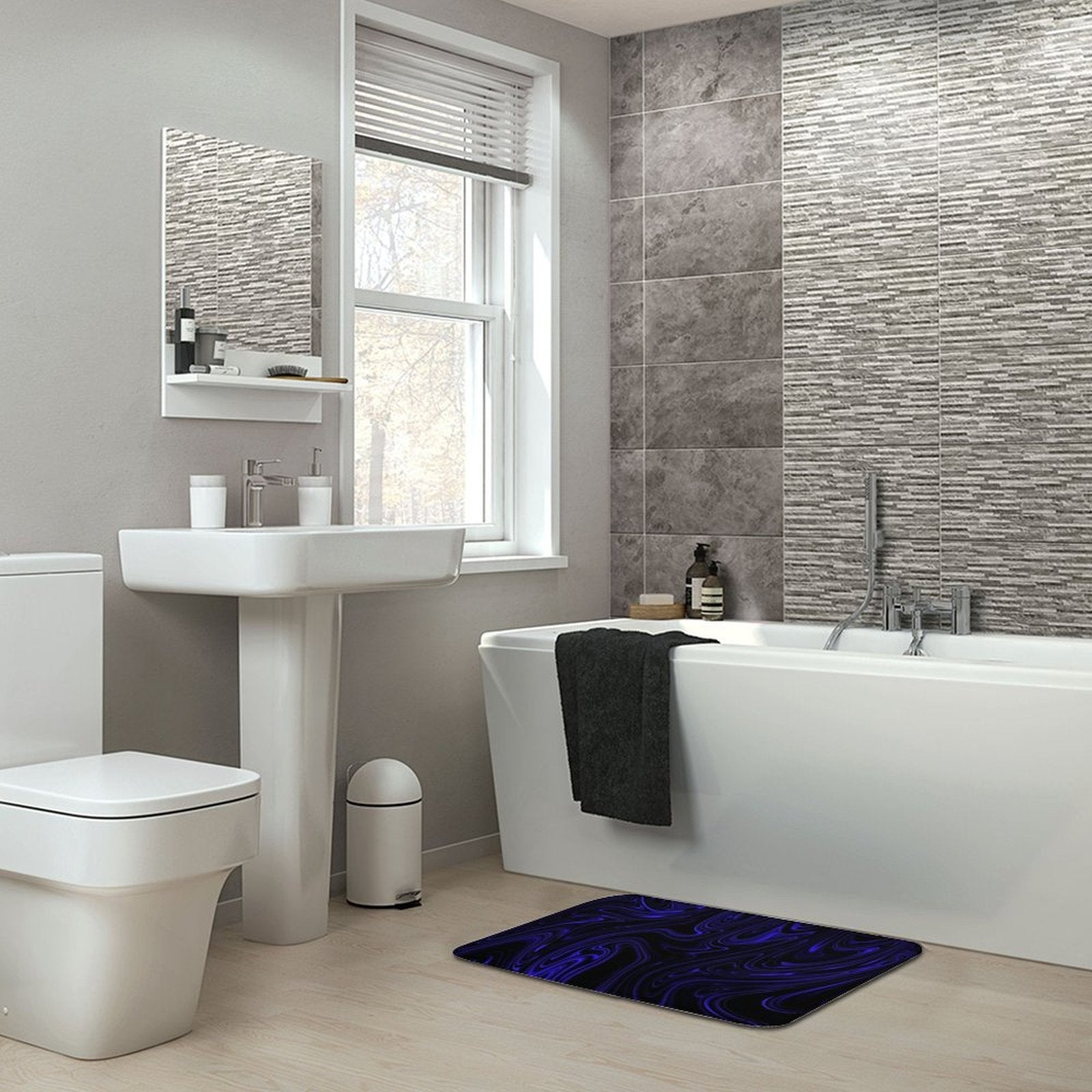 Flow (01-02): Cobalt, The Heavenly Depths bath rug placed in a modern grey-tiled bathroom setting. Archival design adds a kinetic pop to a minimalist interior.