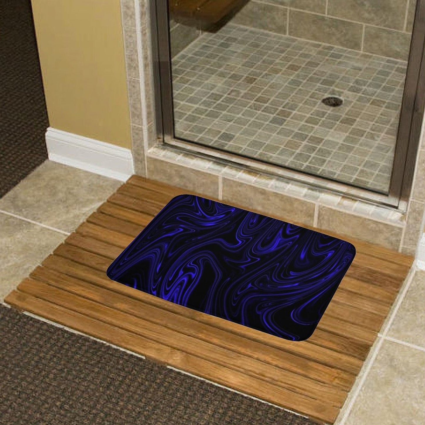 Flow (01-02): Cobalt bath rug on a wooden slat mat by a glass shower door. Highlights the contrast between the organic fluid design and natural textures.