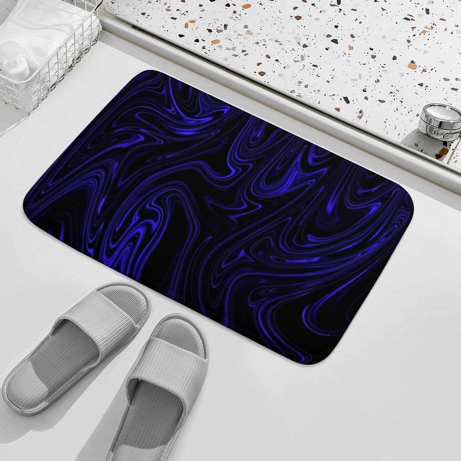 Overhead perspective of the Flow (01-02) Cobalt bath rug. Showcases the full "Heavenly Depths" fluid pattern alongside neutral-toned spa slippers.