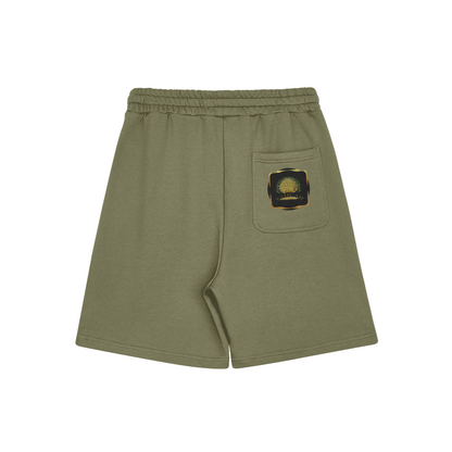 Alt Text: Flat lay of sage green Yahuah: Tree of Life sweat shorts featuring a golden tree emblem on the back pocket against a white background.