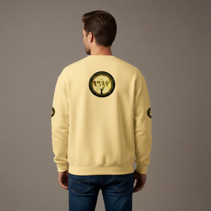 Rear view of a man wearing a pale yellow crewneck sweatshirt and dark blue jeans. A large, circular graphic is centered on the upper back, matching the design on the front chest: a dark silhouette of a figure with arms raised against a textured, parchment-like background with ancient-style lettering. Small, matching circular logos are visible on the outer mid-sleeves.