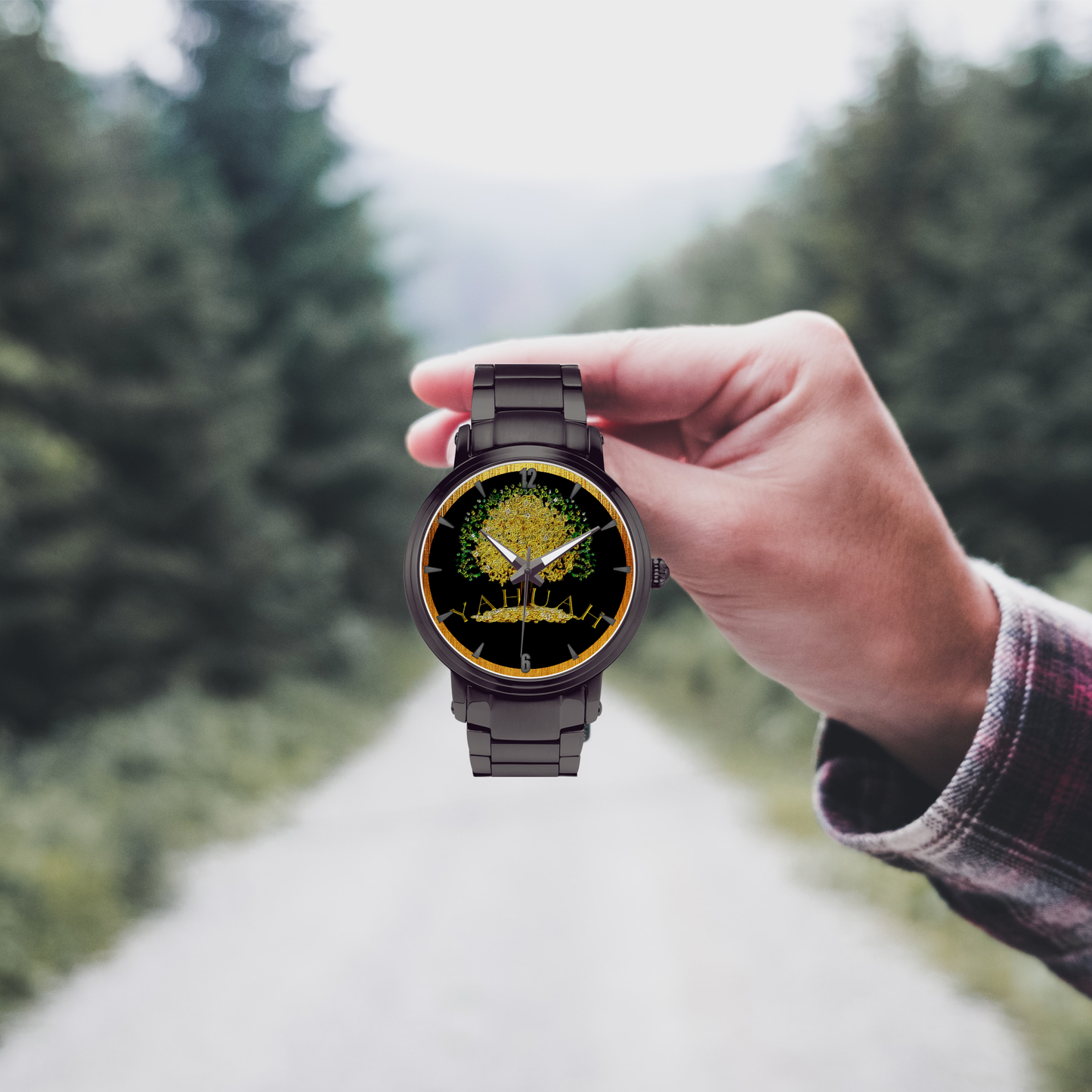 Yahuah: Tree of Life (03) automatic watch collection in black stainless steel, held by a hand in front of a forest road.