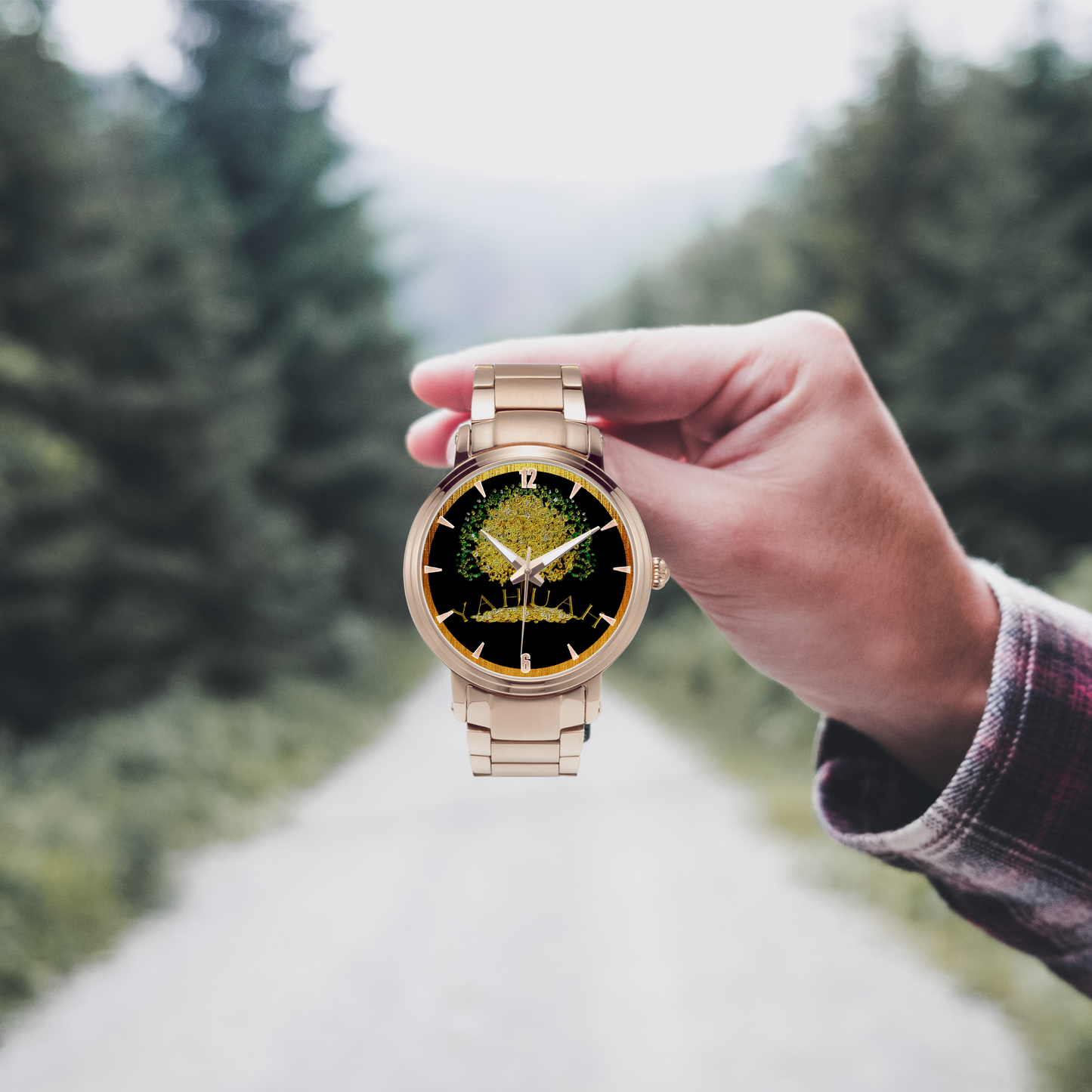 Yahuah: Tree of Life (03) automatic watch in rose gold stainless steel, held by a hand in front of a forest road.