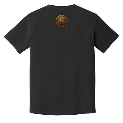 Flat lay of a black adult heavyweight tee showing the back with a circular gold "I AM" badge below the collar.
