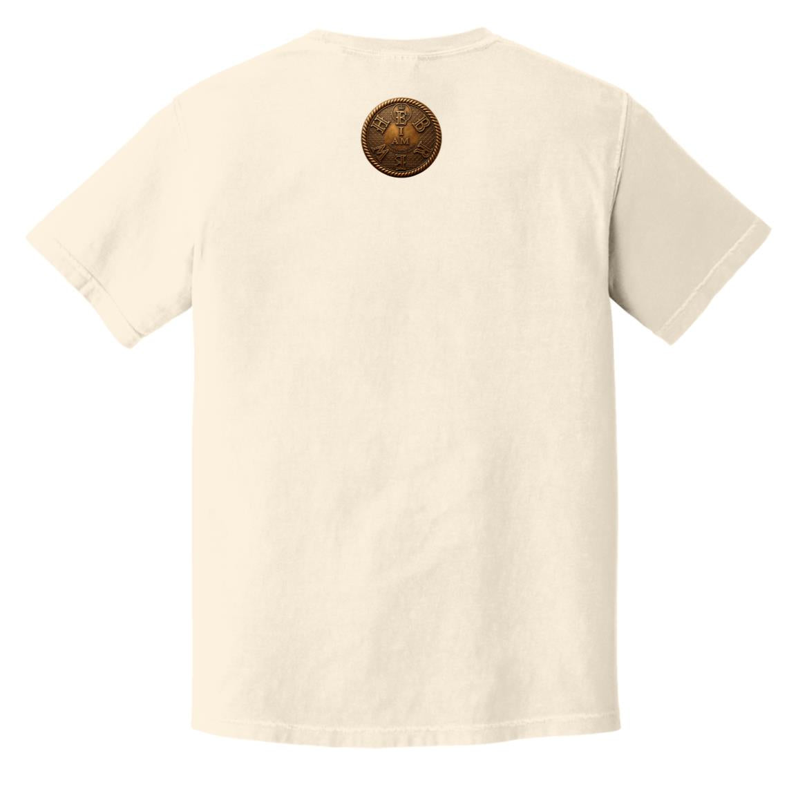 Flat lay of an ivory adult heavyweight tee showing the back with a circular gold "I AM" badge below the collar.