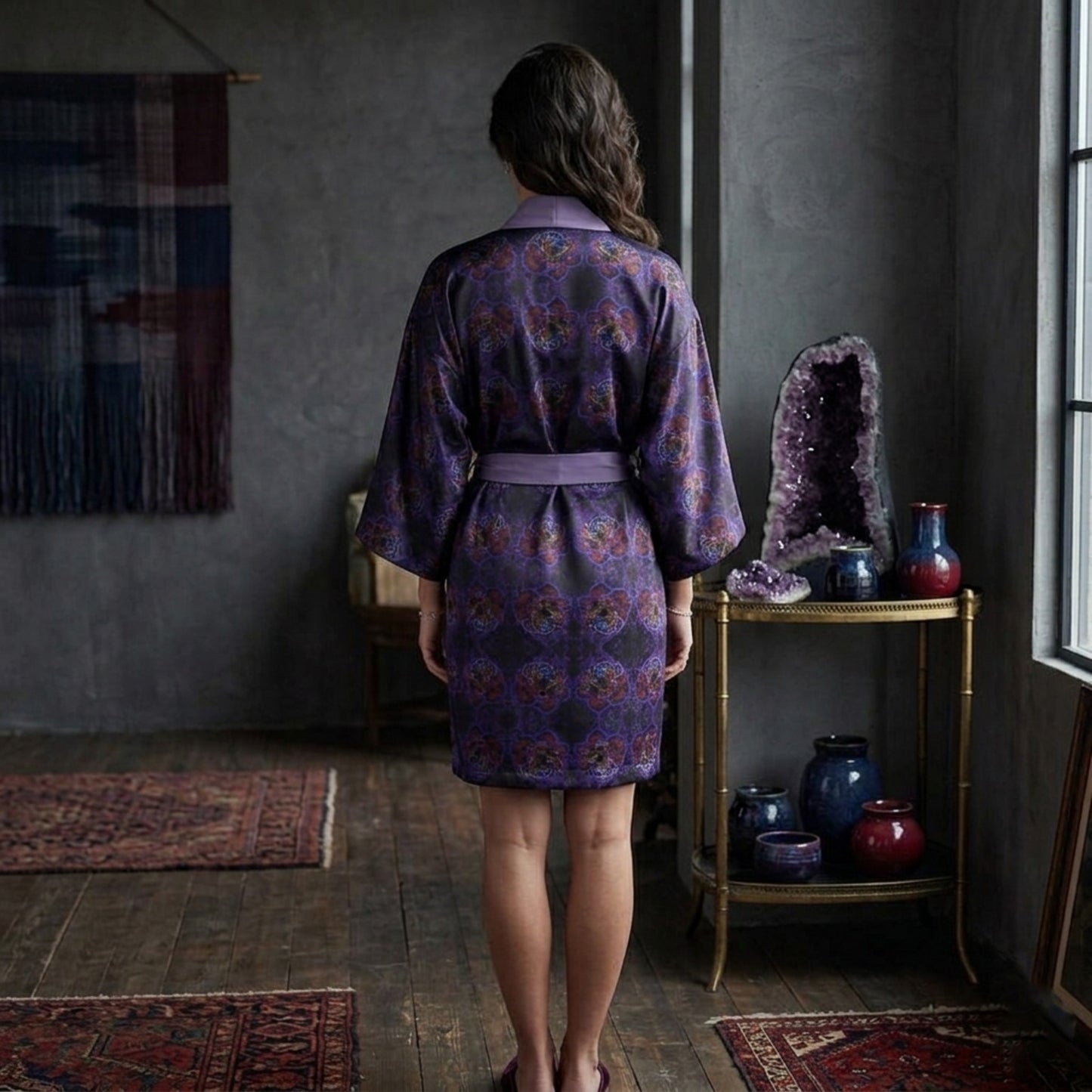 Back view of the Nocturnal Sanctuary silk kimono robe showcasing the symmetrical floral emboss design and elegant drape in a moody, interior setting.