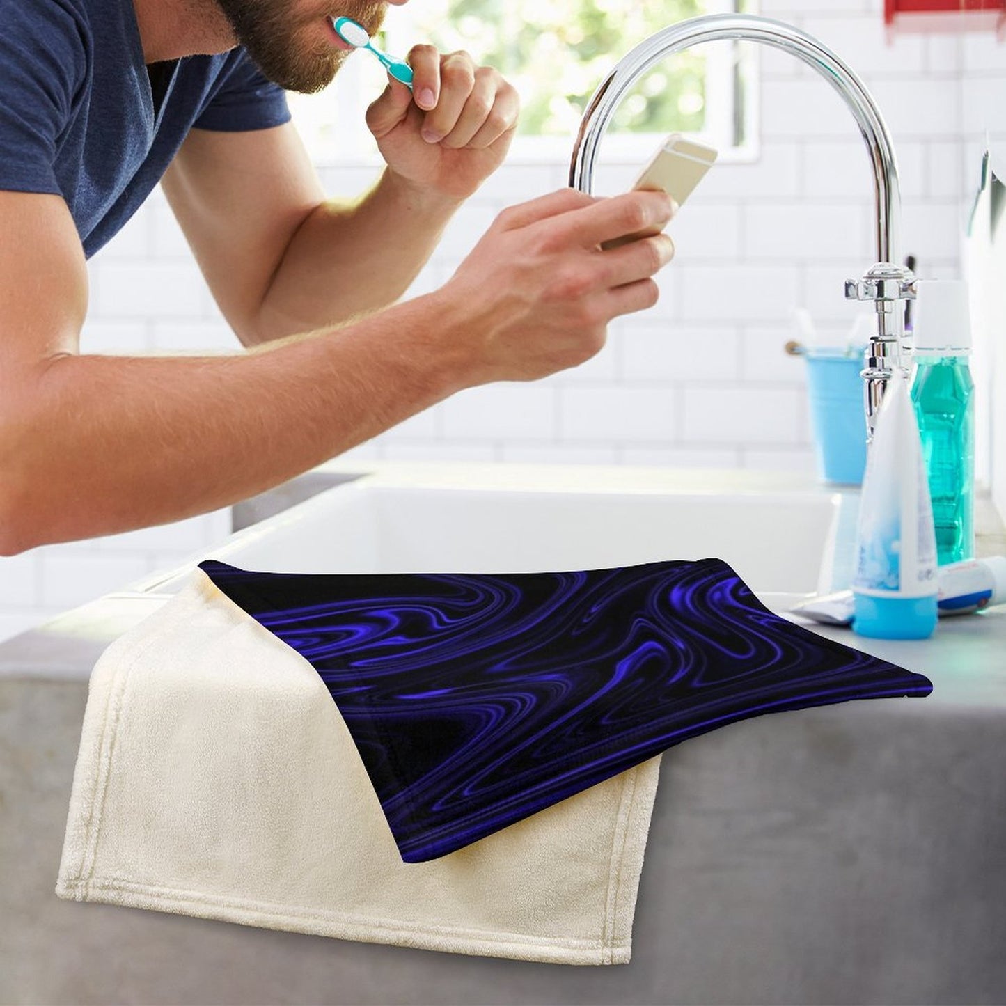 A blue and black marble patterned hand towel resting on a bathroom counter near a sink, showcasing the soft coral velvet material.