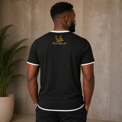 Back view of the black Fly Solo ringer tee with white trim, highlighting the golden eagle emblem and brand name on the upper back.