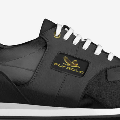 Direct lateral side view of the men's Fly Solo sneaker, showing the black leather panels, textured overlays, and white midsole.