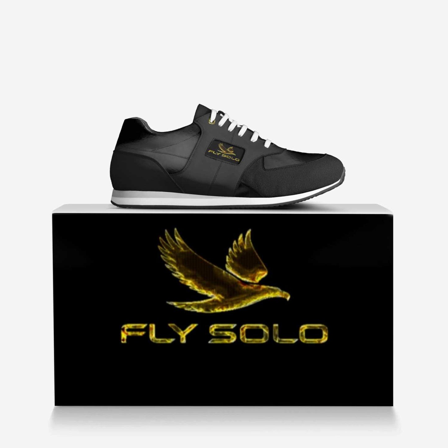 Close-up shot of the Fly Solo golden bird logo and brand name embossed on a black leather panel of the shoe.