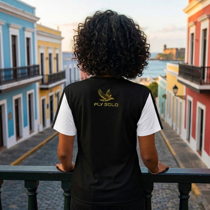 Back view of the split-panel fashion tee featuring white sleeves, a black body, and the gold brand logo.