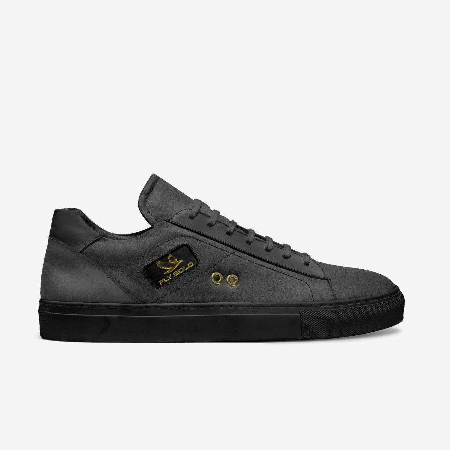 A side profile of the women's all-black Fly Solo sneaker. It shows the detailed texture of the dark grey leather, the gold eagle logo, and the black sole.