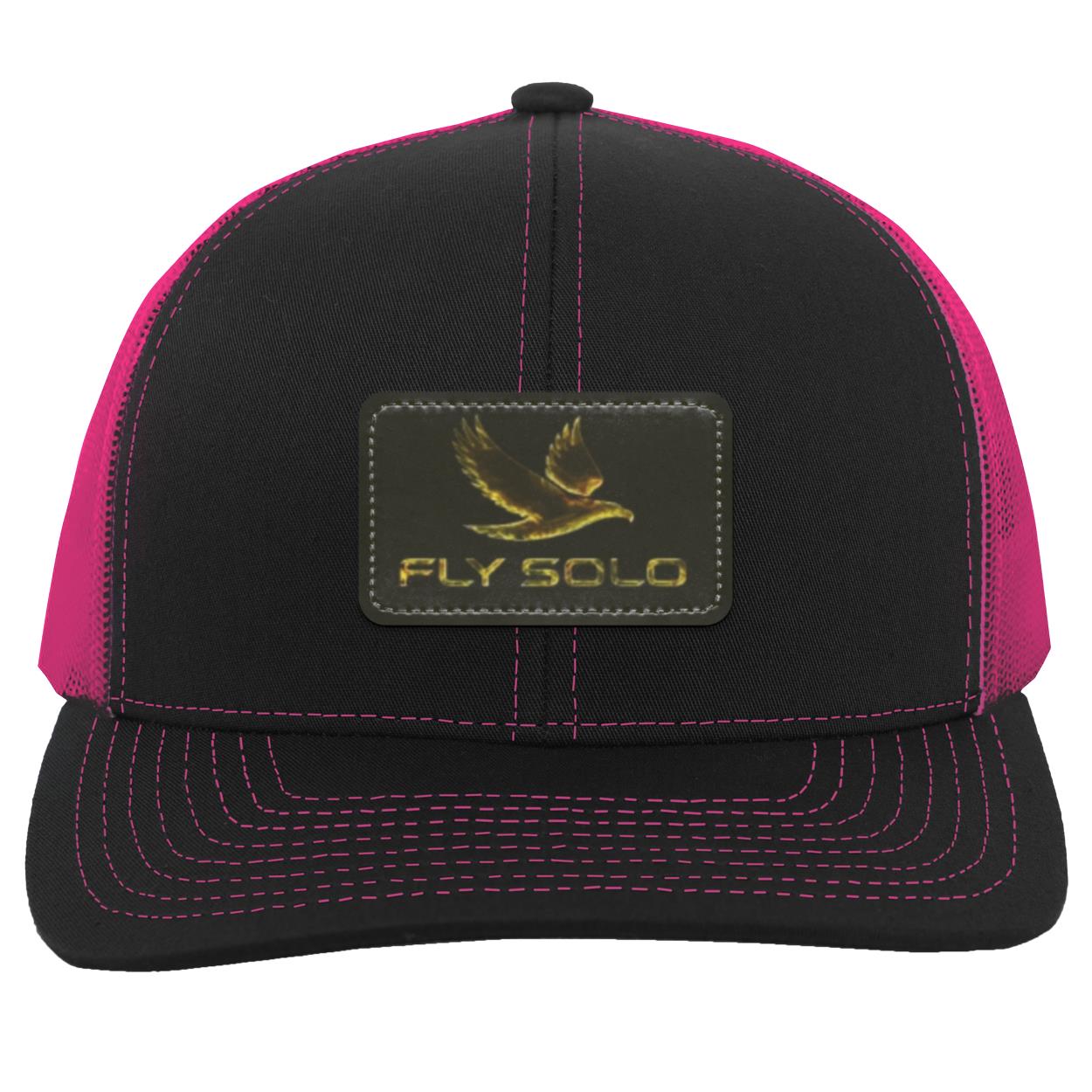 Front product shot of the black Fly Solo trucker snapback with vibrant pink mesh and a signature gold eagle leather patch.