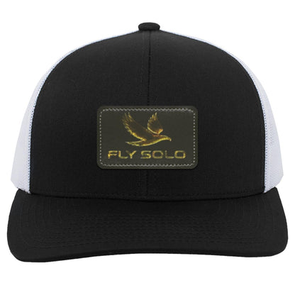 Front product shot of the black and white Fly Solo trucker snapback featuring the signature gold eagle leather patch.