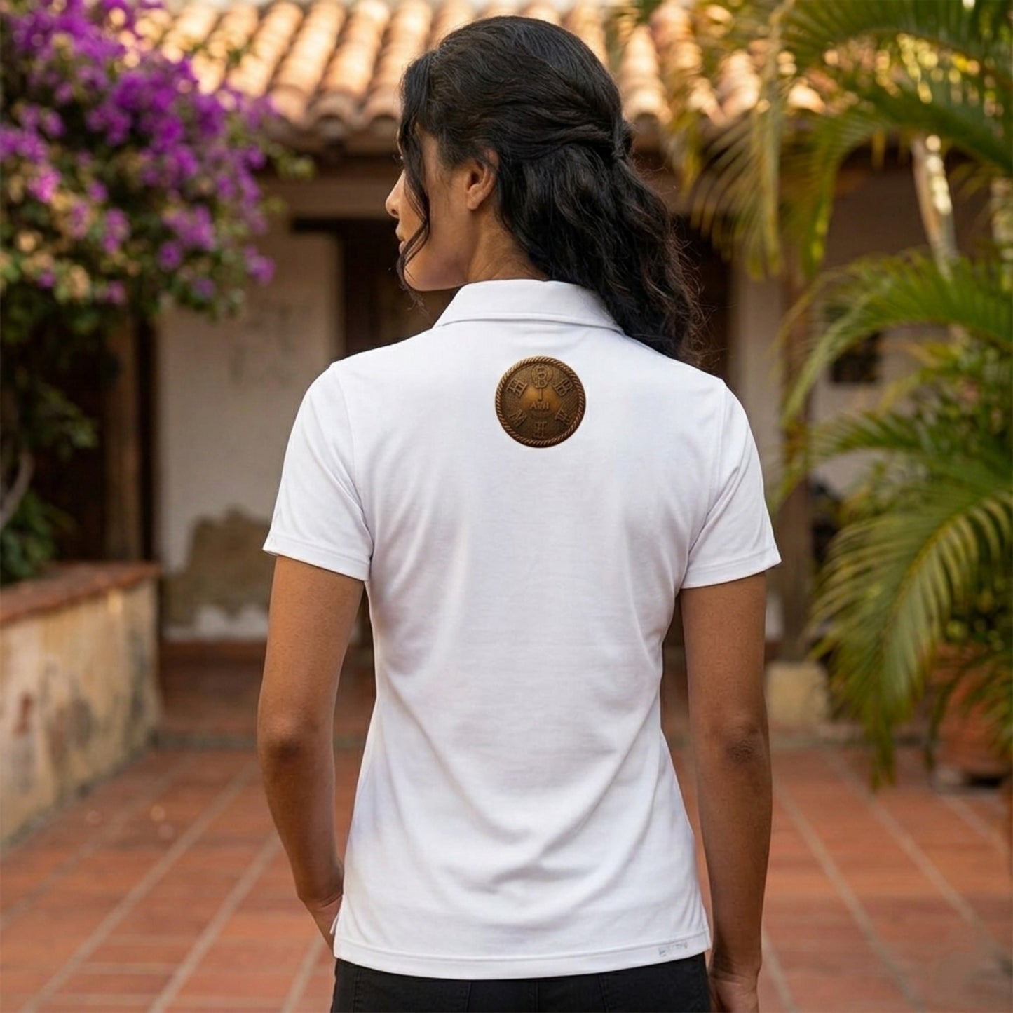 Back view of a woman modeling the adult white "I AM HEBREW" Force Sun Defender polo shirt, showing the circular bronze logo below the collar.