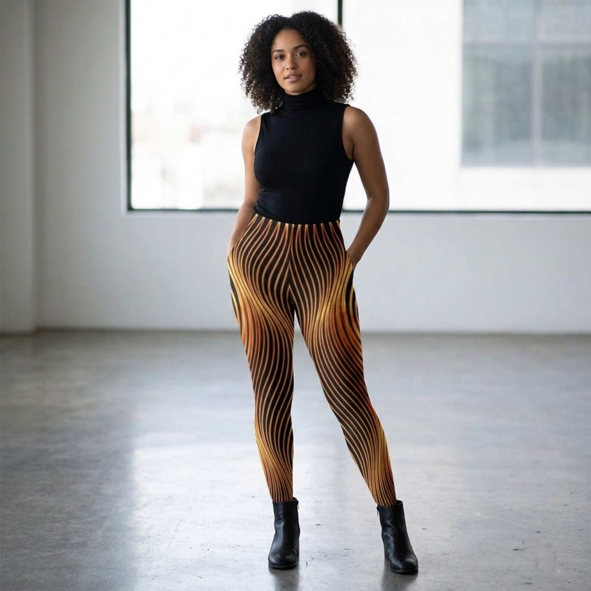 Front view of a model with curly hair wearing Orot Series Esh Tamid high-stretch tights featuring an orange and black wavy flame pattern.