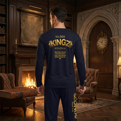 Back view of a man in a library wears a navy long-sleeve shirt with "144,000 KINGZ" in gold. The front features a Bible graphic; the back displays a Revelation 1:6 verse.