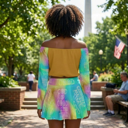 Back view of a woman in a park wearing a mustard off-the-shoulder top with colorful tie-dye patterned sleeves and a matching mini skirt.