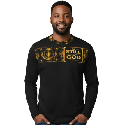 Man in long sleeve tee featuring a gold "Sacred Stillness" design with "Be Still" plaque across the chest.
