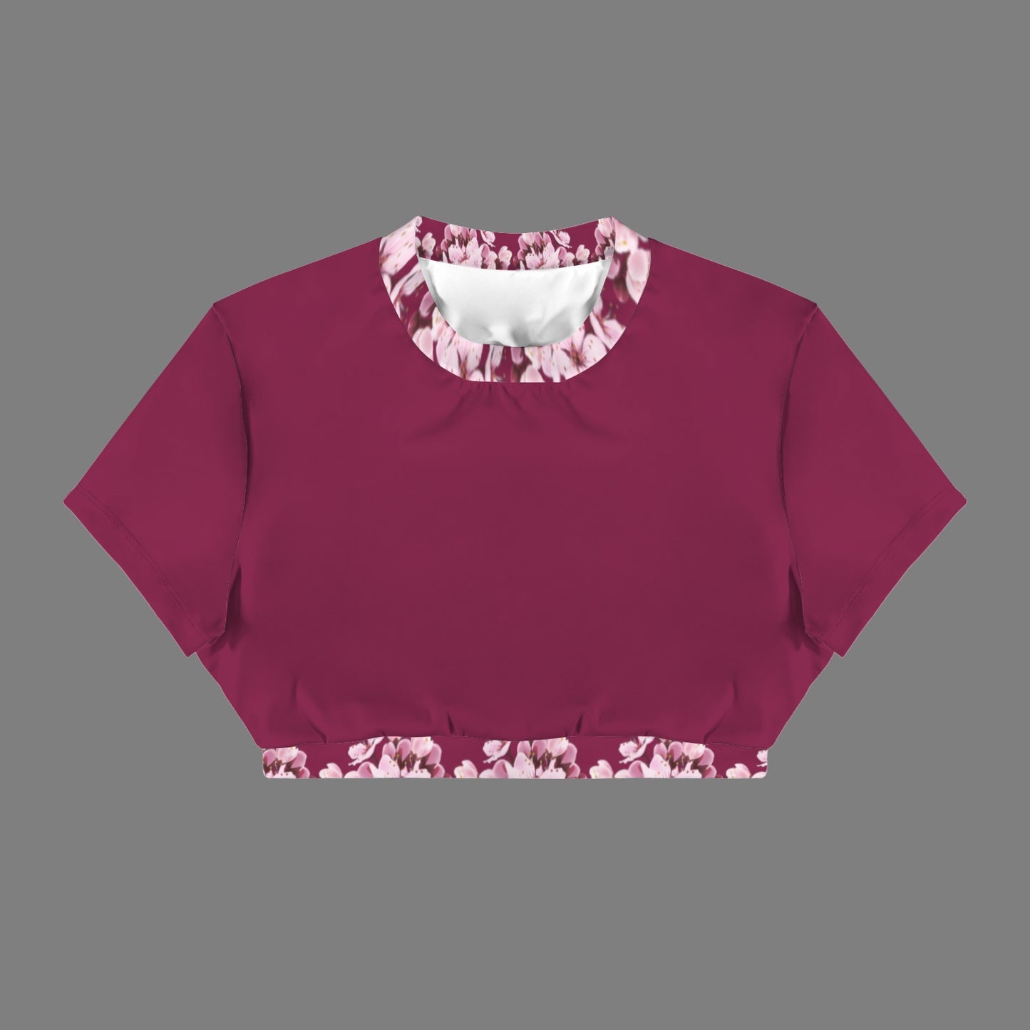 Product flat lay of the Sakura Symphony open-back crop top in magenta, showcasing the pink floral print on the crew neck and lower waistband.