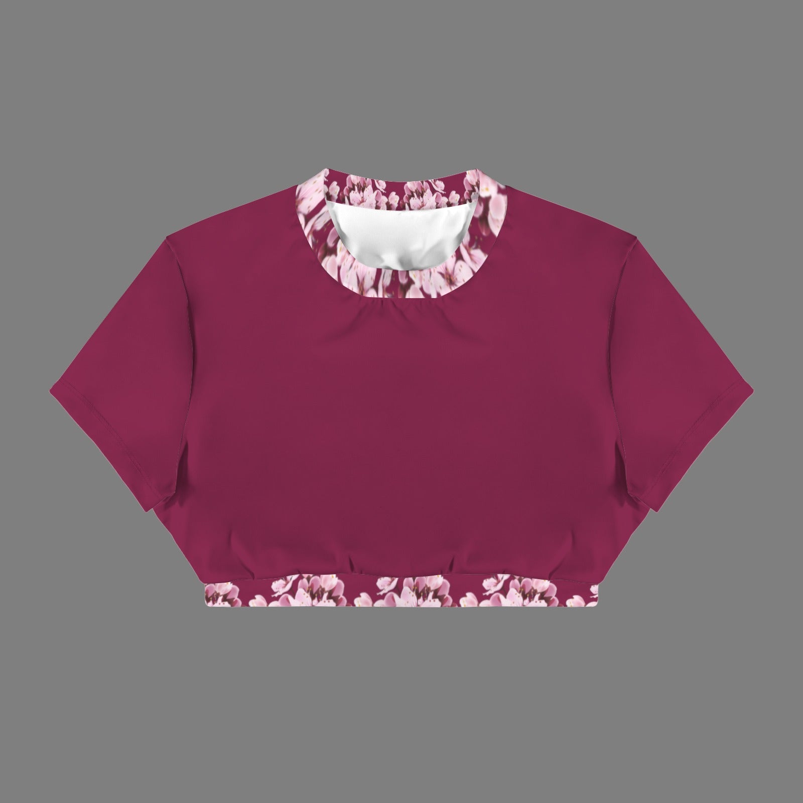 Product flat lay of the Sakura Symphony open-back crop top in magenta, showcasing the pink floral print on the crew neck and lower waistband.