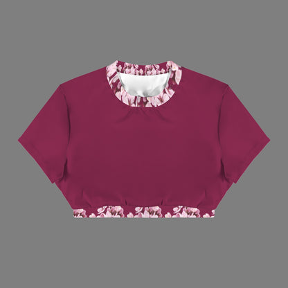 Product flat lay of the Sakura Symphony open-back crop top in magenta, showcasing the pink floral print on the crew neck and lower waistband.