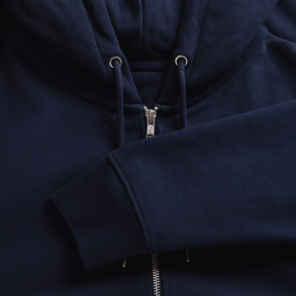 Close-up texture shot of a navy blue organic zip hoodie displaying the silver zipper assembly, metal eyelets, and neatly stitched ribbed cuff.