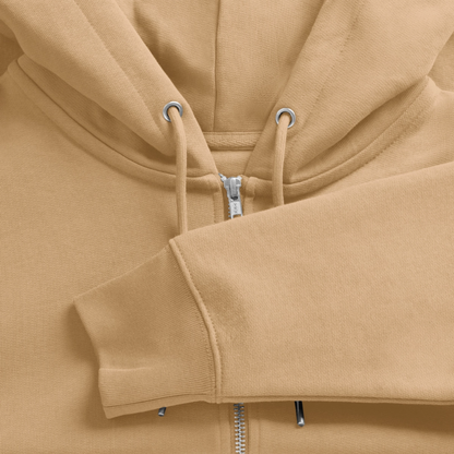 Detailed close-up of an off-white organic zip hoodie, focusing on the silver metal zipper, matching drawstrings, and heavy-knit cotton fabric texture.