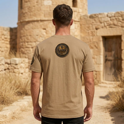 Back view of a tan oversized heavyweight t-shirt featuring a large, central circular antiqued bronze medallion emblem with Paleo-Hebrew typography.