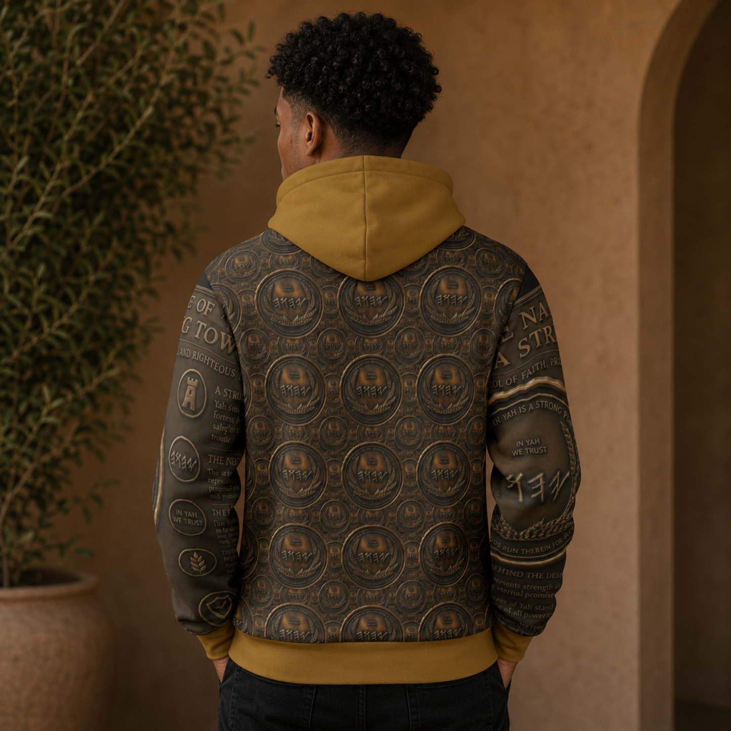 Back view of a black hoodie showcasing a full, intricate repeat pattern of antiqued bronze seals, a solid gold hood, and ribbed waist trim.