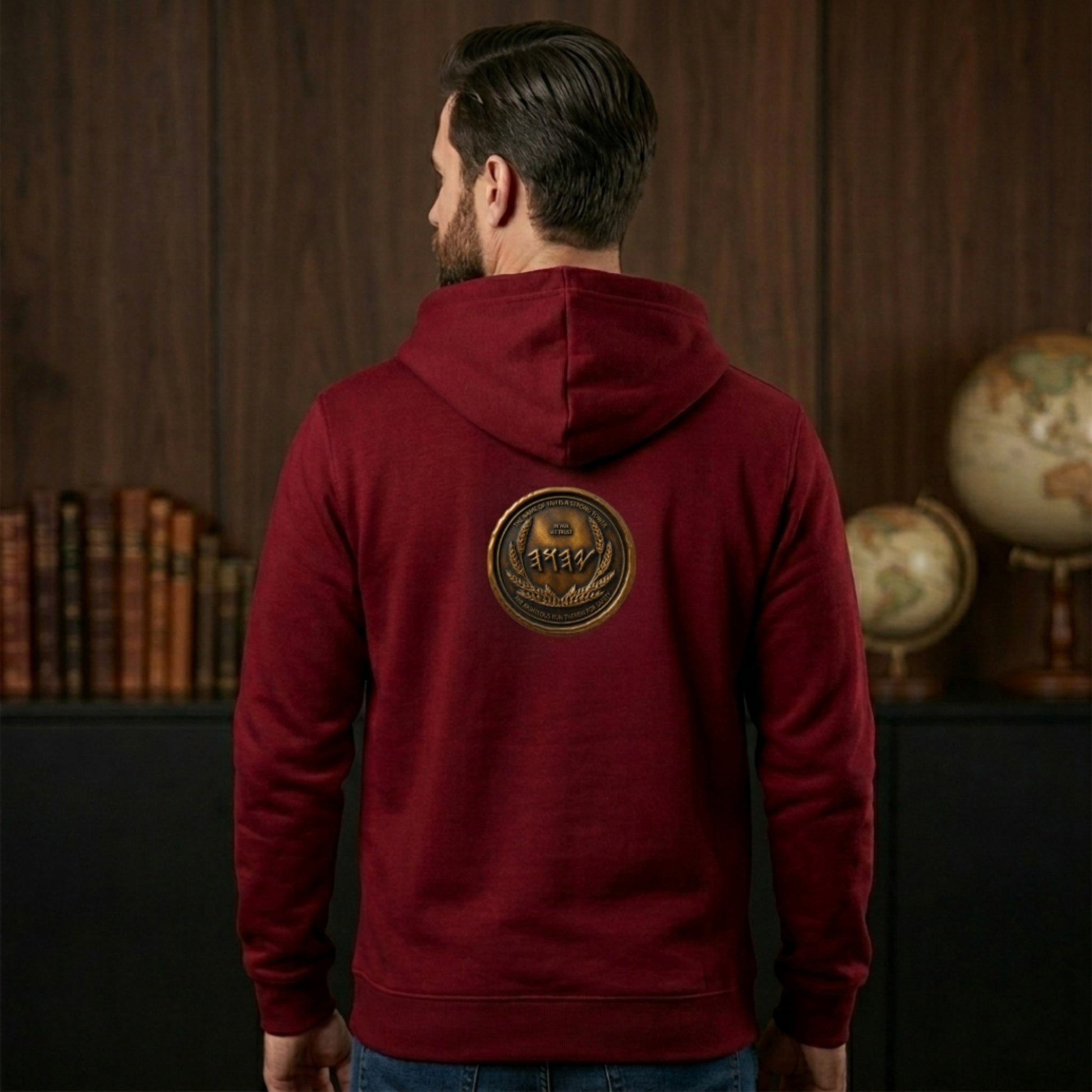 Back view of a burgundy organic zip hoodie displaying a large, centered circular antiqued bronze medallion emblem with Paleo-Hebrew text.