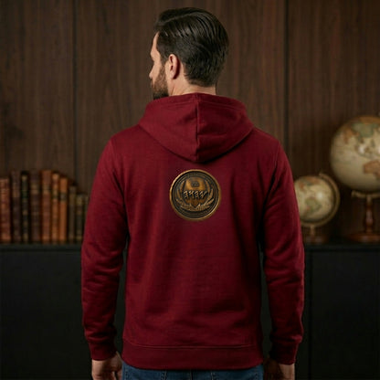 Back view of a burgundy organic zip hoodie displaying a large, centered circular antiqued bronze medallion emblem with Paleo-Hebrew text.