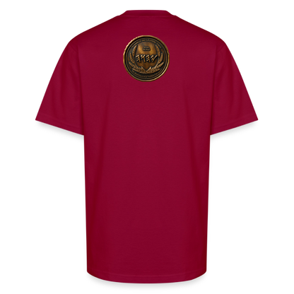 Back view of a burgundy oversized heavyweight t-shirt featuring a large circular antiqued bronze Paleo-Hebrew medallion emblem centered on the upper back.