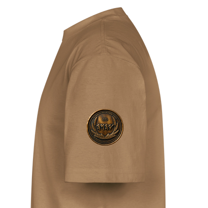 Side profile view of a tan oversized heavyweight t-shirt, highlighting a circular antiqued bronze symbolic medallion on the right sleeve fabric.