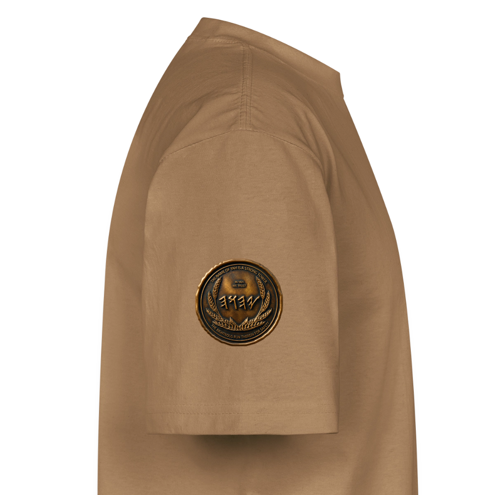 Side profile showing the left sleeve of a tan oversized heavyweight t-shirt with a circular antiqued bronze medallion emblem printed near the hem.