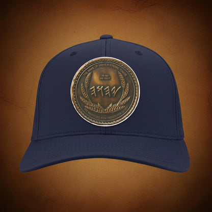 Front view of a deep navy blue twill baseball cap with an intricately layered, circular antiqued bronze emblem showcasing sacred typography.