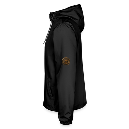 Left side profile view of a black lightweight windbreaker with a circular antiqued bronze Paleo-Hebrew script medallion on the upper sleeve.