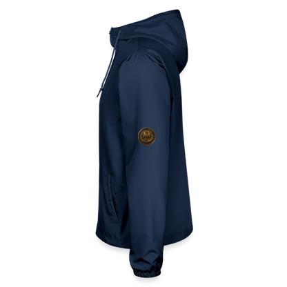 Left side profile view of a navy blue lightweight windbreaker with a circular antiqued bronze Paleo-Hebrew script medallion on the upper sleeve.