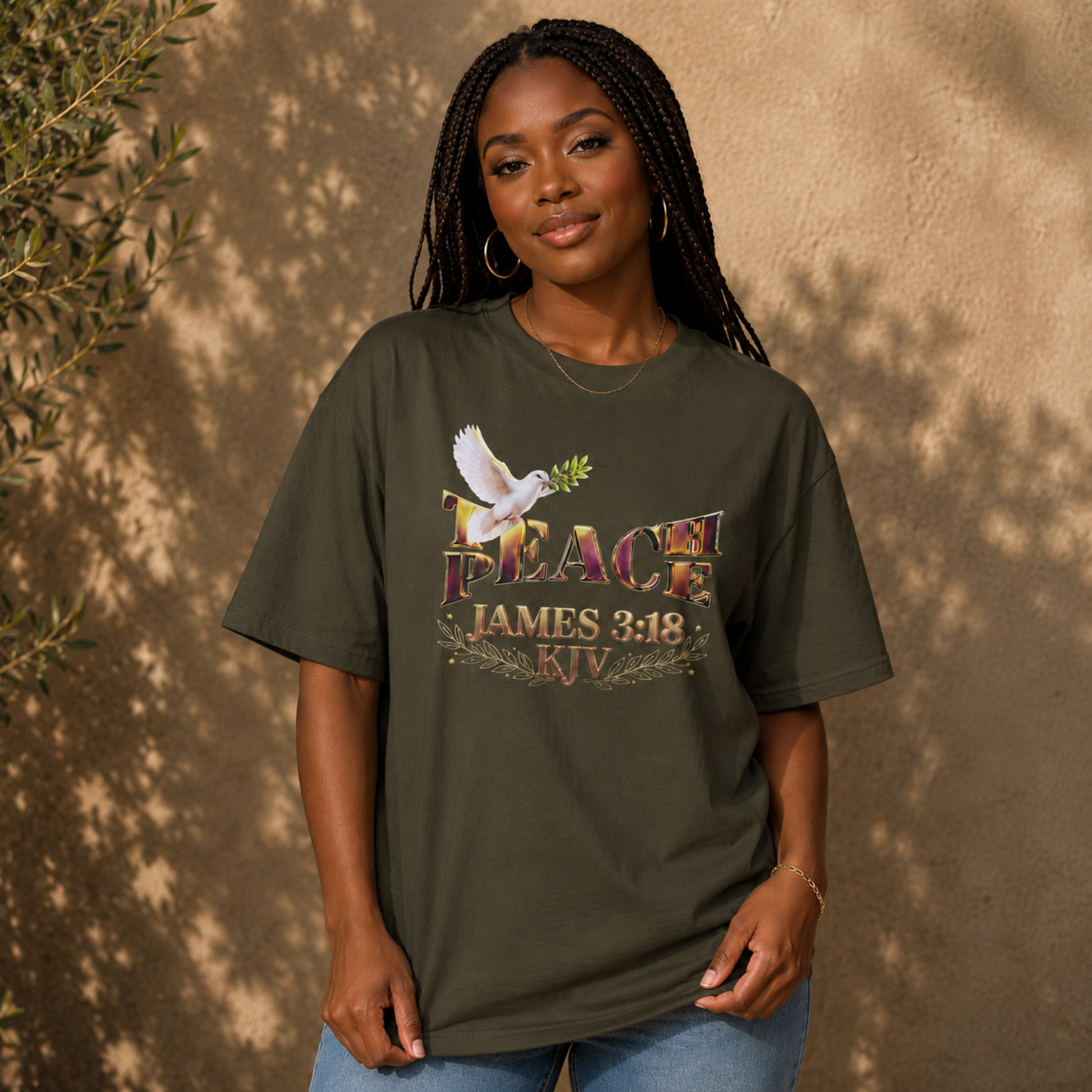 A woman with braided hair wearing the olive green Teach Peace James 3:18 heavyweight oversized tee.