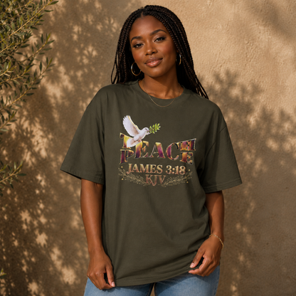 A woman with braided hair wearing the olive green Teach Peace James 3:18 heavyweight oversized tee.