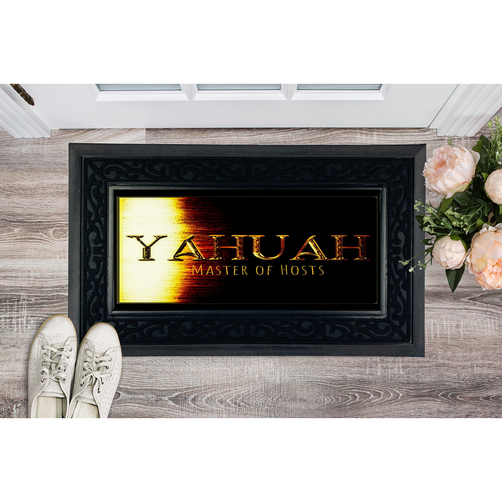Yahuah Master of Hosts heavy-duty door mat mockup with a black border, placed on a wood floor next to white sneakers and pink flowers.